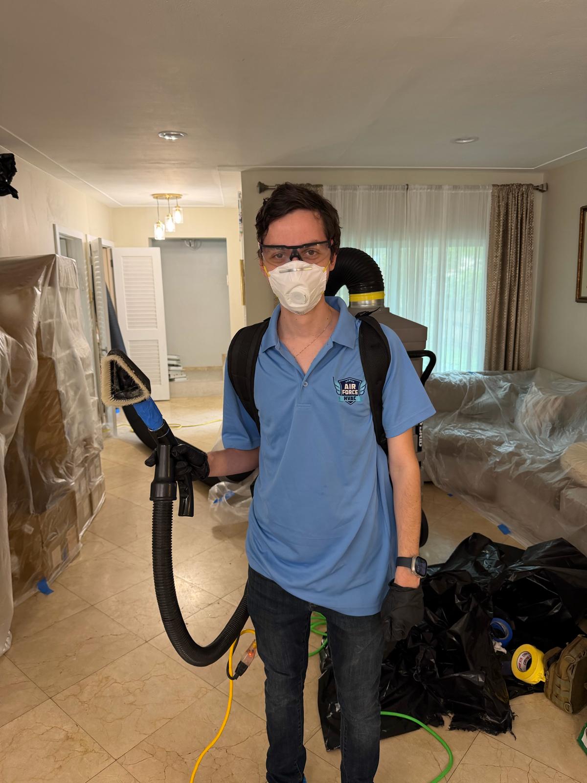 Air Force HVAC team inspecting inside a large commercial blower unit