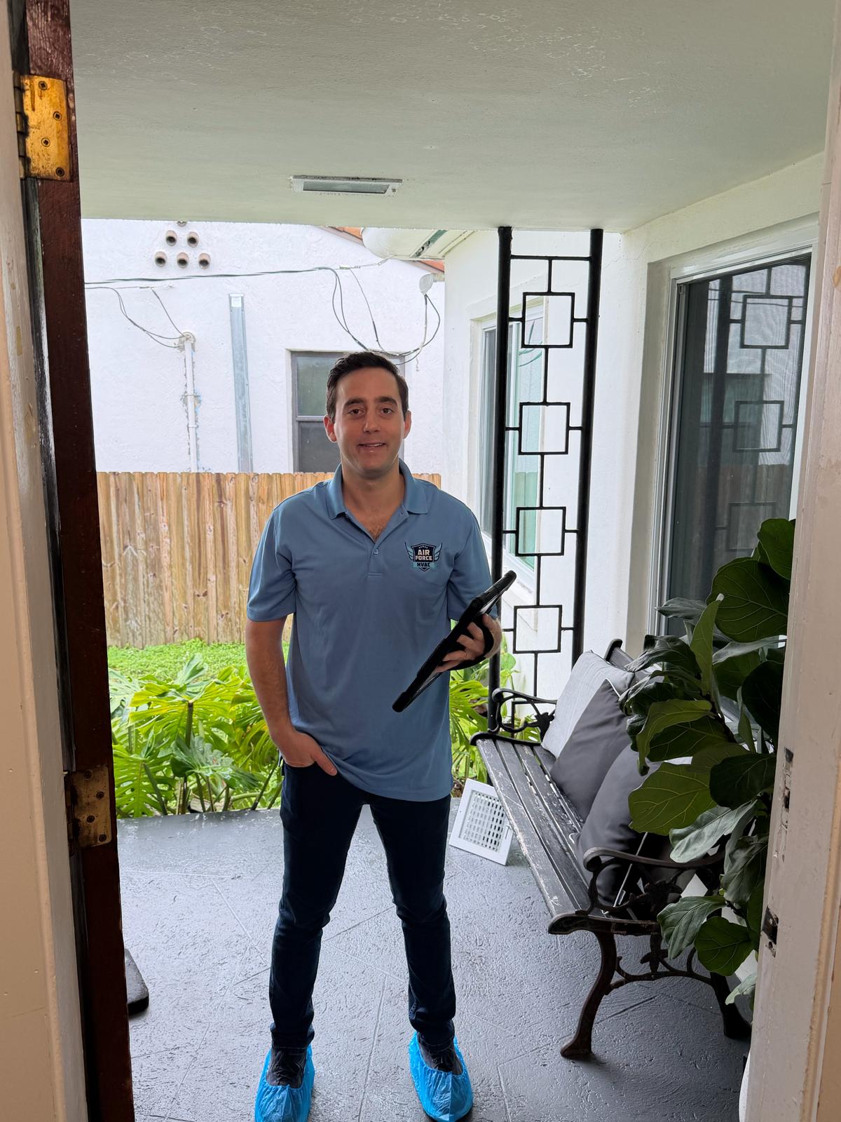 Air Force HVAC technician arriving at customer front door with shoe covers