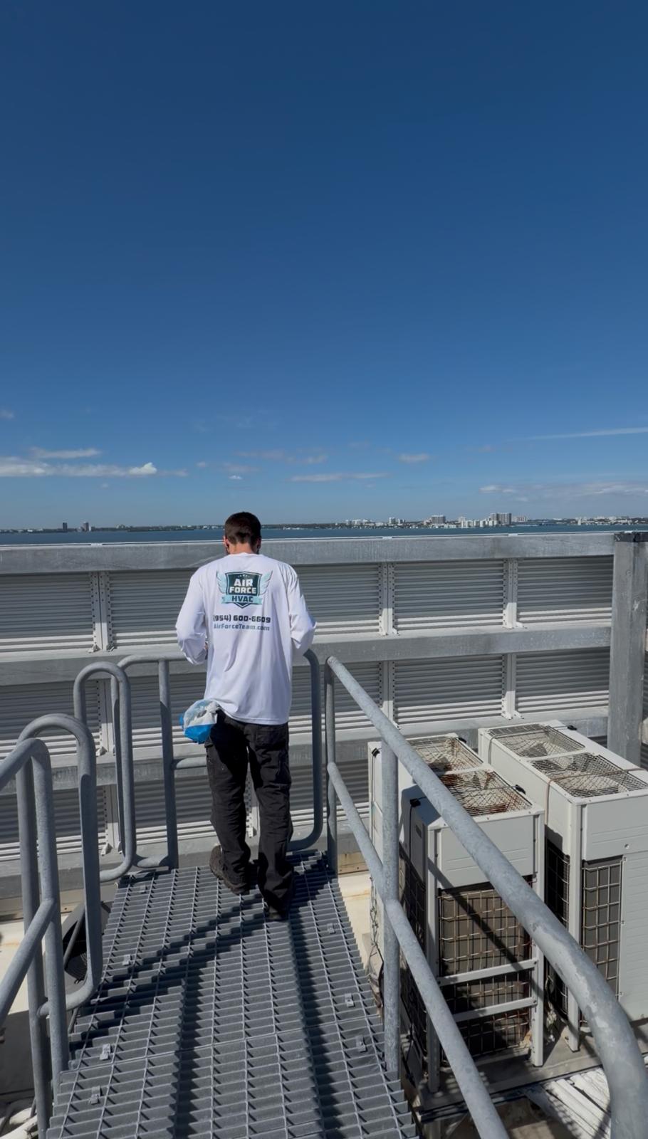 Air Force HVAC technician with HEPA backpack vacuum performing duct cleaning